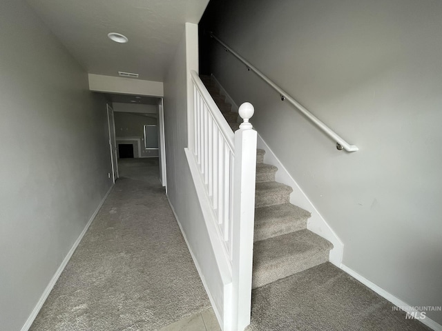 stairway featuring carpet and baseboards