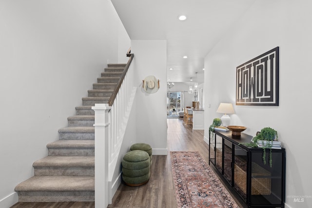 stairs featuring baseboards, wood finished floors, and recessed lighting