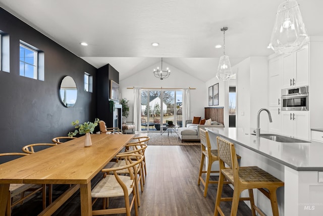 dining room featuring a chandelier, dark wood-type flooring, lofted ceiling, and recessed lighting