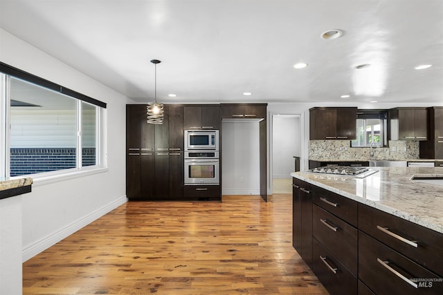 kitchen with appliances with stainless steel finishes, light wood-style floors, dark brown cabinets, baseboards, and recessed lighting