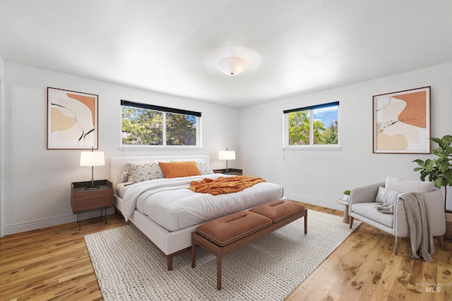 bedroom with light wood-style flooring and baseboards
