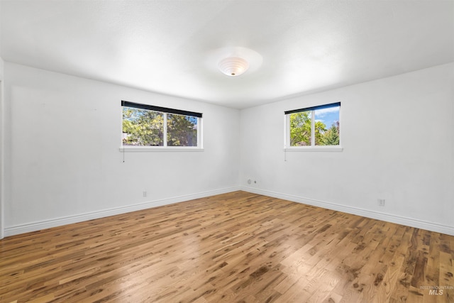 unfurnished room featuring wood finished floors and baseboards
