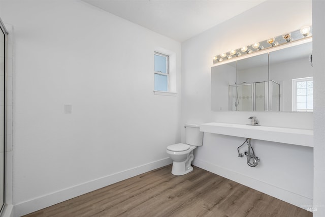 full bathroom featuring a shower stall, toilet, wood finished floors, and baseboards
