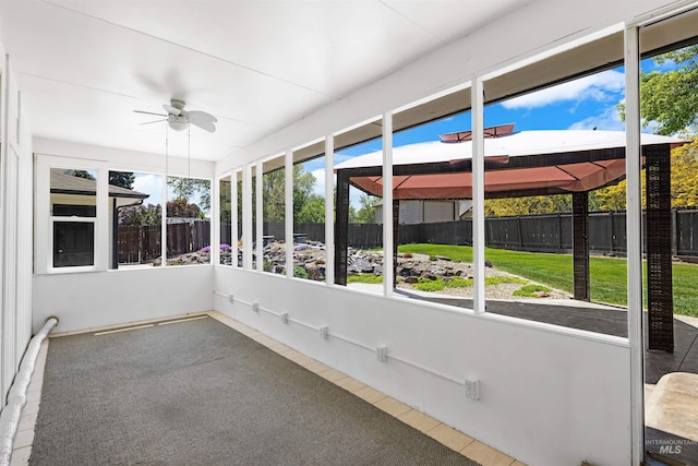 unfurnished sunroom featuring ceiling fan