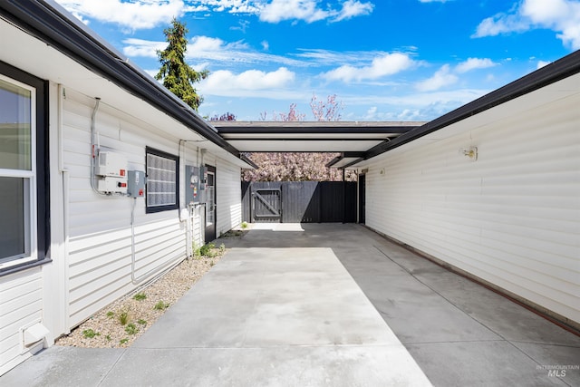 view of patio featuring fence, a carport, and a gate