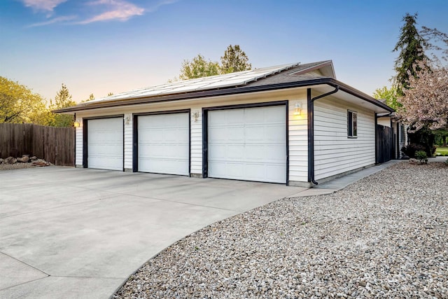 detached garage with roof mounted solar panels and fence