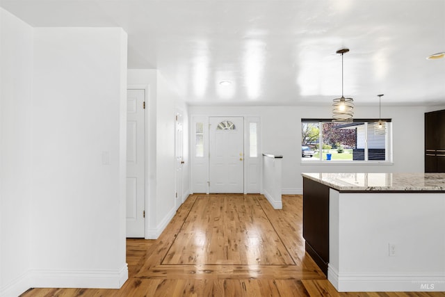 entryway featuring light wood-style flooring and baseboards
