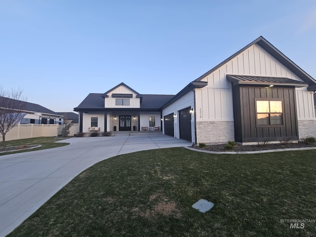 modern farmhouse style home featuring board and batten siding, a garage, a front yard, fence, and driveway