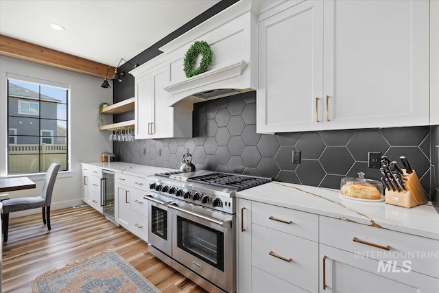 kitchen featuring light wood-style flooring, open shelves, beverage cooler, white cabinets, and range with two ovens