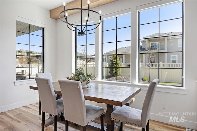 dining space with visible vents, baseboards, an inviting chandelier, and wood finished floors