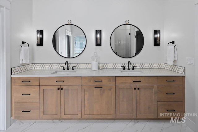 full bathroom featuring double vanity, marble finish floor, a sink, and backsplash