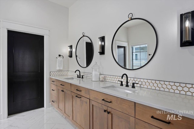 bathroom featuring double vanity, marble finish floor, a sink, and decorative backsplash