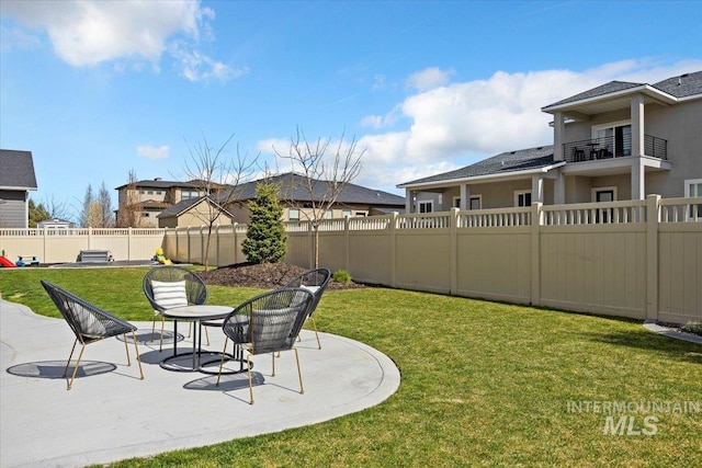 view of yard with a patio area, a fenced backyard, and a residential view