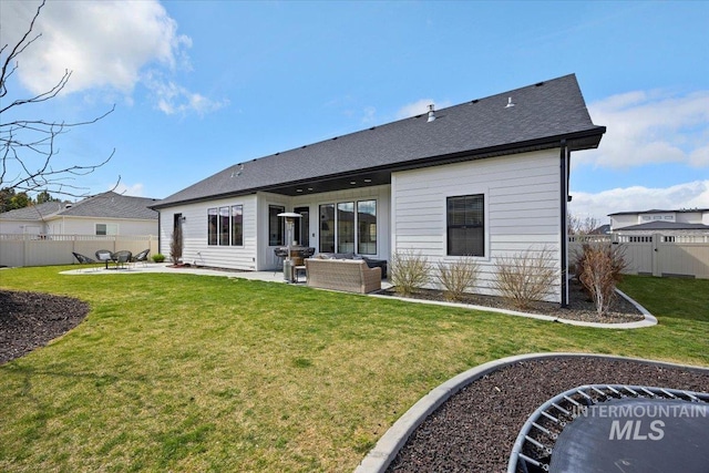 back of house with a patio, roof with shingles, an outdoor living space, a yard, and fence