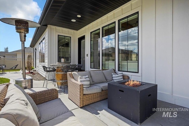 view of patio with an outdoor living space with a fire pit