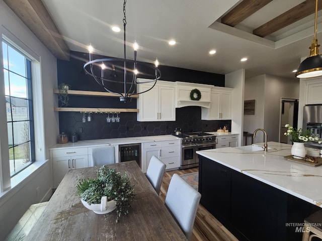 kitchen with a notable chandelier, plenty of natural light, beverage cooler, and stainless steel appliances