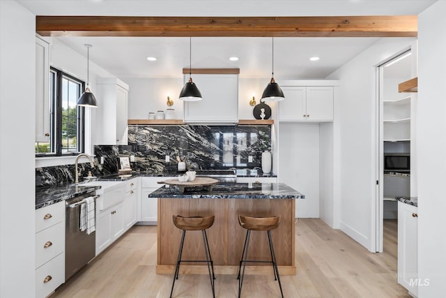 kitchen with a center island, light hardwood / wood-style flooring, tasteful backsplash, and white cabinetry