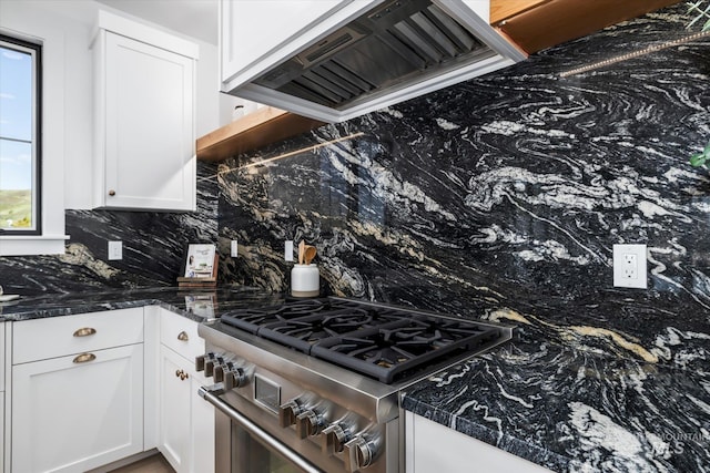 kitchen with a healthy amount of sunlight, backsplash, white cabinetry, and custom range hood