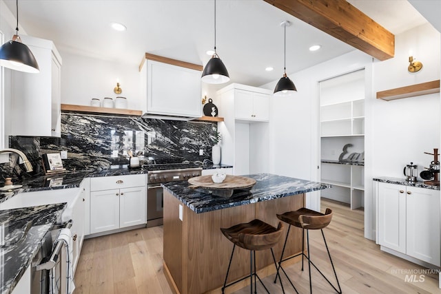 kitchen with backsplash, white cabinetry, and light hardwood / wood-style flooring