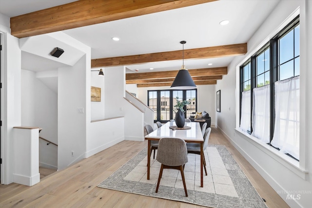 dining area featuring beam ceiling, french doors, and light hardwood / wood-style flooring