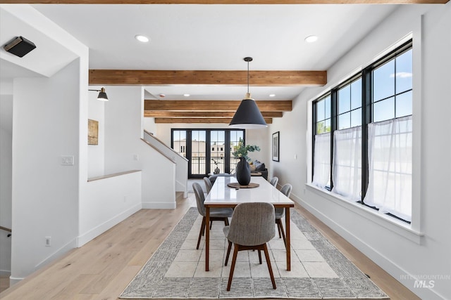 dining space featuring beamed ceiling, french doors, and light wood-type flooring