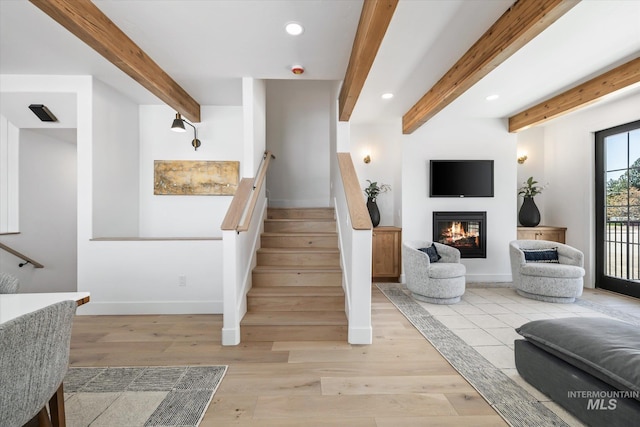 stairs with beam ceiling and light hardwood / wood-style flooring