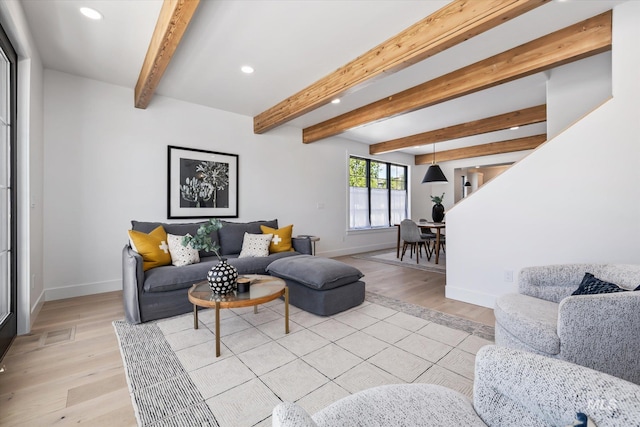 living room featuring beamed ceiling and light hardwood / wood-style flooring