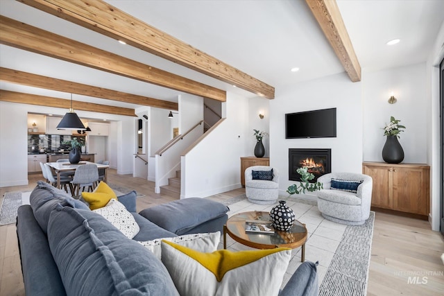 living room featuring beamed ceiling and light wood-type flooring