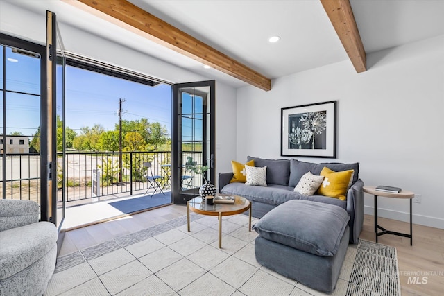 living room featuring beamed ceiling, plenty of natural light, and light hardwood / wood-style floors