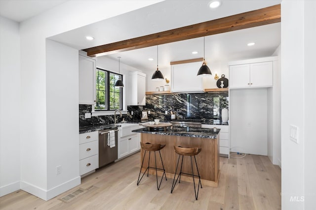 kitchen with dishwasher, white cabinets, a center island, and light hardwood / wood-style flooring