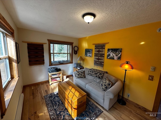 95 Valley Way, Stanley, ID 83278 - living room with wood finished floors, a textured ceiling, baseboards, and a baseboard radiator