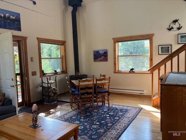 95 Valley Way, Stanley, ID 83278 - dining space featuring baseboard heating, a high ceiling, healthy amount of natural light, a wood stove, and wood finished floors