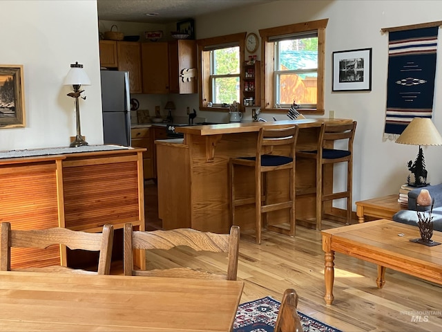 95 Valley Way, Stanley, ID 83278 - kitchen with freestanding refrigerator, light wood finished floors, a breakfast bar area, and light countertops