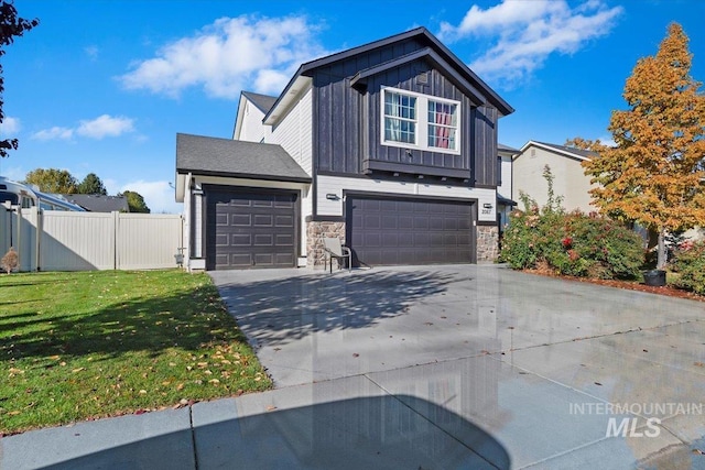 view of front of home featuring board and batten siding, fence, stone siding, and a front lawn