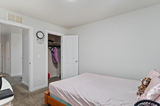 bedroom featuring a walk in closet, visible vents, carpet floors, baseboards, and a closet