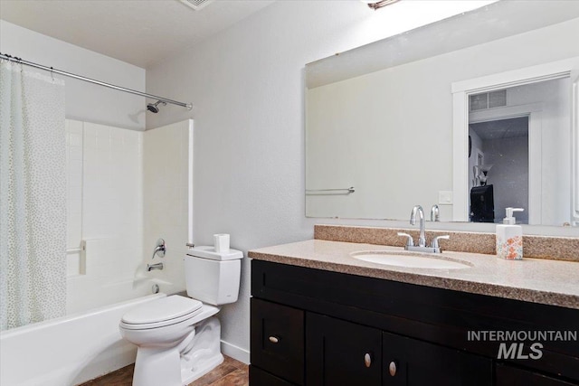 bathroom featuring vanity, toilet, wood finished floors, shower / tub combo, and visible vents