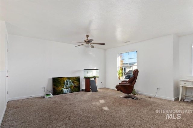 sitting room with a ceiling fan, baseboards, and carpet