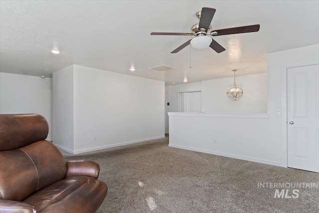 living area featuring baseboards, carpet flooring, ceiling fan with notable chandelier, and visible vents