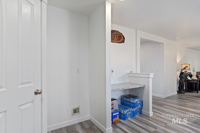 hallway with baseboards and wood finished floors