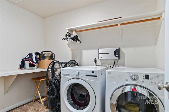 clothes washing area with laundry area, baseboards, and washing machine and dryer