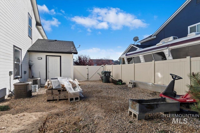 view of yard featuring central air condition unit, fence, and a gate
