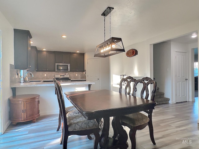 dining room featuring sink and light hardwood / wood-style flooring