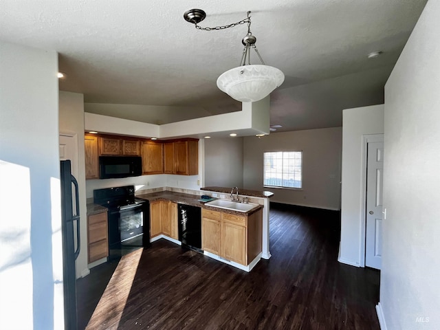 kitchen with kitchen peninsula, black appliances, lofted ceiling, pendant lighting, and sink