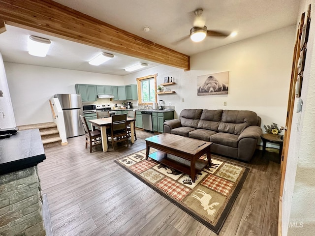 living room with beam ceiling, hardwood / wood-style flooring, and ceiling fan