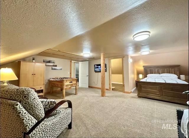 carpeted bedroom featuring a textured ceiling and lofted ceiling