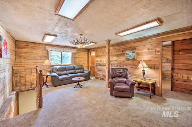 carpeted living room with a textured ceiling and wooden walls