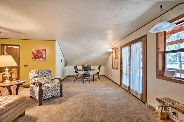 sitting room featuring carpet, a textured ceiling, and lofted ceiling