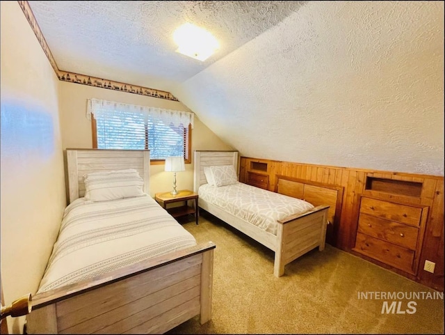 carpeted bedroom with lofted ceiling, wood walls, and a textured ceiling