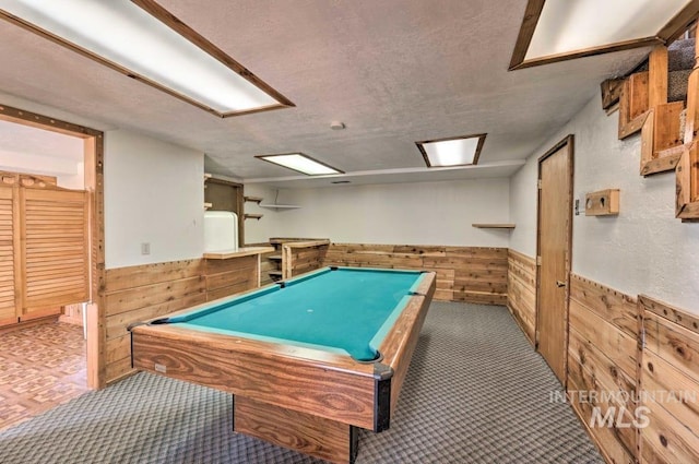 rec room with a textured ceiling, wooden walls, and pool table