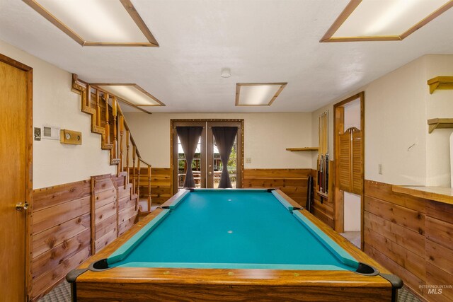 game room with wood walls and billiards